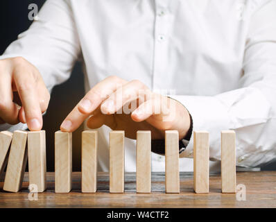 Unternehmer hält Zusammenbruch domino Effekt. Stressresistenz. Die finanzielle Stabilität. Erholung business. Bewertung der Risiken. Erstellen einer Str Stockfoto