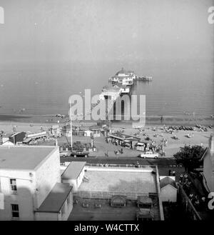 Eine typisch englische/Britische Badeurlaub Szene in den 1940er oder 1950er Jahre ein Pier, wie ich glaube, in Cromer und Massen von Touristen in der Sonne angezeigt Stockfoto