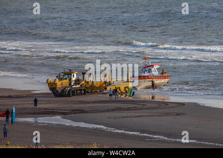 Egmond aan Zee, Niederlande - 22 Juli 2019: Mitglieder der niederländischen Küstenwache Haul ein rettungsboot der Nordsee auf einer Raupe nach einer Rettung dri Stockfoto