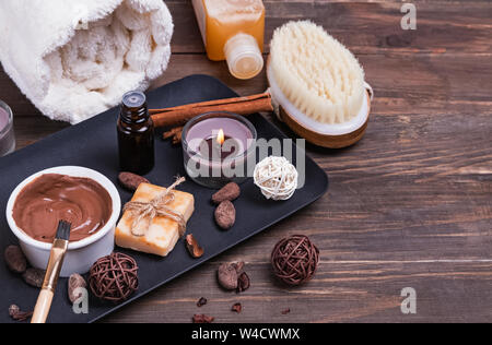 Schokolade Spa auf der hölzernen Hintergrund gesetzt, close-up. Body Care essentials, Aroma Öle und andere Stockfoto