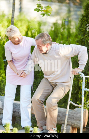 In voller Länge Porträt der fürsorglichen Krankenschwester helfen älteren Menschen von parkbank in der Rehabilitation Center erhalten, kopieren Raum Stockfoto