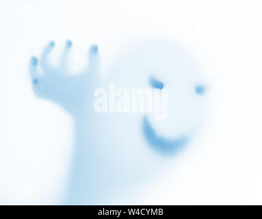 Halloween verschwommenen Hintergrund. Ein Geist wie ein Kürbis in Farbe hinter Glas. Schrecklich und schrecklichen Alptraum. Er klopft an, um das Fenster Stockfoto