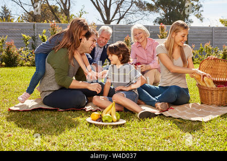 Familie mit Kindern und Großeltern feiert Geburtstag und macht ein Picknick Stockfoto