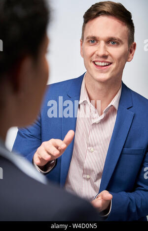 Studio Shot der Geschäftsmann interviewen Geschäftsfrau für Beschäftigung vor weißem Hintergrund Stockfoto