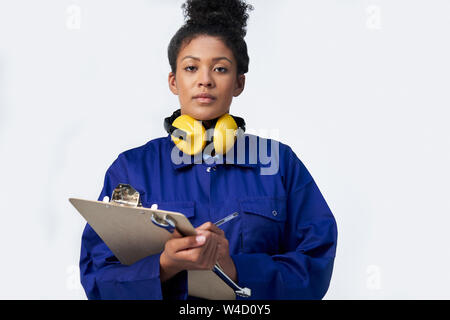 Portrait von Studio Shot der Ingenieurin mit Klemmbrett und Schraubenschlüssel gegen den weißen Hintergrund Stockfoto