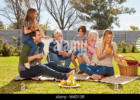 Glückliche Familie mit Kindern und Großeltern feiert Geburtstag im Garten Stockfoto