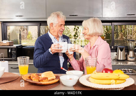 Gerne älteres Paar ist eine Tasse Kaffee beim Frühstück in der Küche Stockfoto