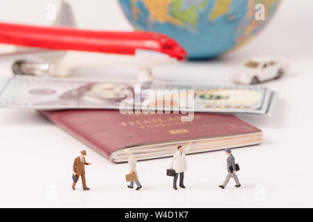 Minifigürchen von Reisenden mit Karte, Flugzeug, Auto, Dollar, Banknote und Pass Hintergrund, Business Konzept Stockfoto