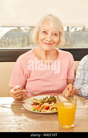 Senior gesund essen Salat und trinken Orangensaft zum Mittagessen Stockfoto