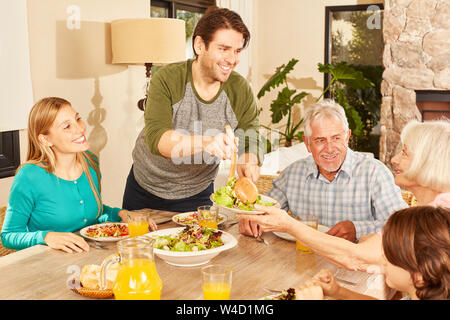 Erweiterte Familie mit Kindern und Großeltern Mittagessen zu Hause in Stockfoto