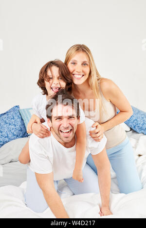 Eltern dumm mit ihrem Sohn im Bett am Morgen im Schlafzimmer Stockfoto