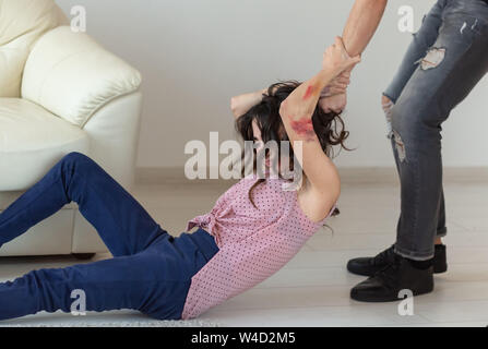 Häusliche Gewalt, Alkohol und Missbrauch Konzept-aggressive Mann packte seine Frau auf dem Boden liegend Stockfoto