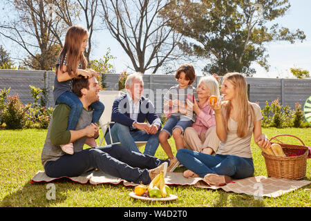 Erweiterte Familie mit Kindern und Großeltern bei einem Picknick im Garten im Sommer Stockfoto