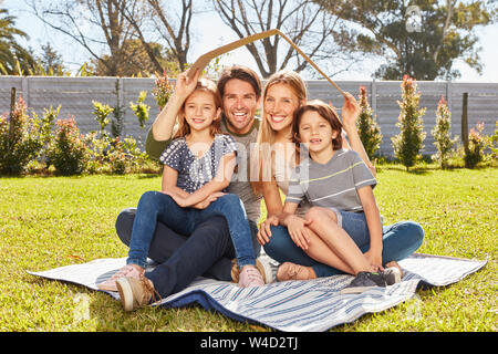 Eltern und zwei Kindern ein Dach über dem Kopf, wie ein Haus und Versicherung Konzept Stockfoto