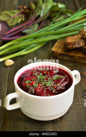 Vegetarisches Essen. Red borscht Suppe in Weiß Schüssel auf hölzernen Tisch Stockfoto