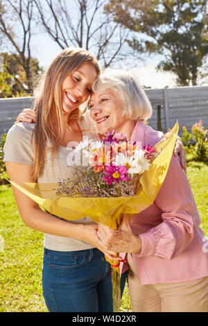 Mutter durch ihre Tochter für den Blumenstrauß zum Muttertag Stockfoto