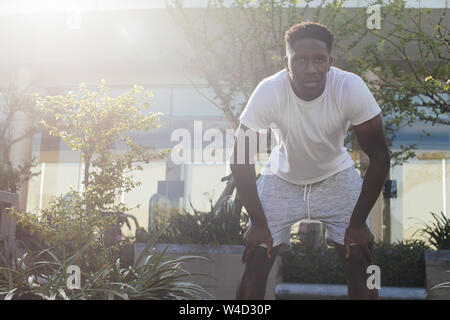 Portrait der afrikanischen amerikanischen Mann eine Pause beim Joggen. Junge männliche Person geeignet, Übung und eine Pause im City Park Stockfoto
