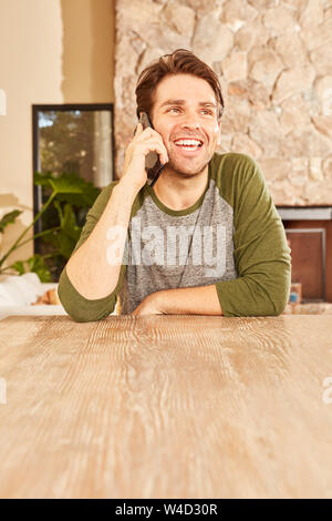 Junge Mann ist, am Telefon zu sprechen oder Smartphone in seiner Wohnung Stockfoto