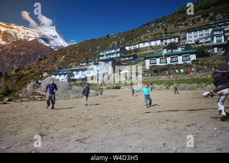 Namche Bazar, Nepal - Oktober 17, 2015: Unbekannte Kinder spielen Fußball auf staubigen Spielplatz, Namche Bazar Stockfoto