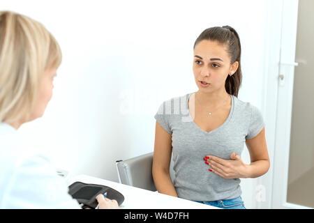 Patient klagt beim Arzt über die Schmerzen. Stockfoto