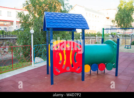 Kinderspielplatz mit lustigen Zug aus bunten Kunststoff und Metall Material, Unterhaltung für Kinder draußen im Park im Sommer Stockfoto