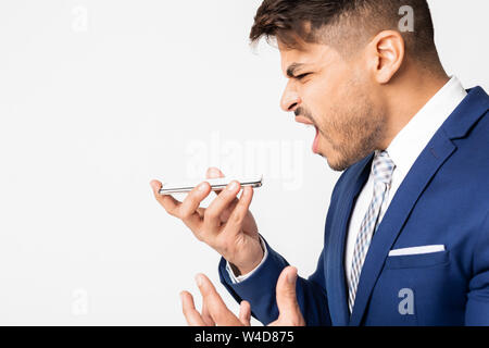 Portrait von Angry Geschäftsmann kreischend an Smartphone auf weißem Hintergrund Stockfoto