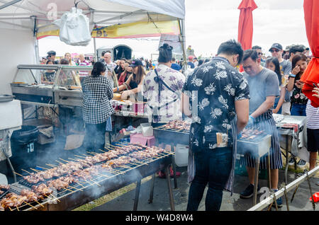 Eine Street Food Catering auf ein Filipino Veranstaltung in London. Schweinefleisch grillen Köche auf Grills von zwei Männern besucht. Stockfoto