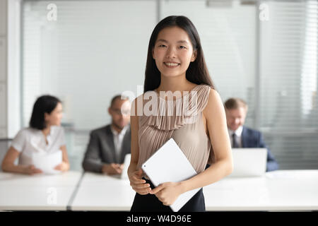 Lächelnden jungen asiatischen Geschäftsfrau Holding digital Tablet an Kamera suchen Stockfoto