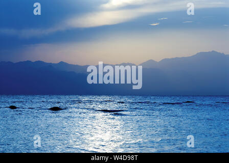 Sonnenuntergang am Meer gegen misty Küste, Aqaba Gulf, Ägypten Stockfoto