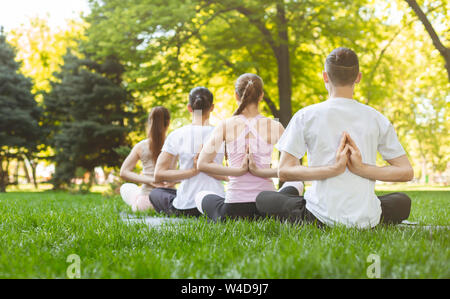 Zurück Blick auf junge Menschen, die Asana Übungen Stockfoto