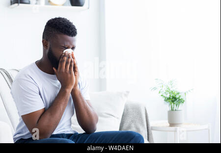 Junge krank afrikanischer Mann Reinigung rotzig Nase Stockfoto