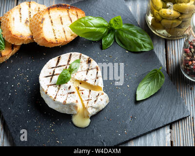 Camembert Grill, auf schwarzen Stein Hintergrund Stockfoto