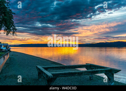 Die Wolken hängen am Himmel, wie die Sonne hinter den Olympic Mountains im Armaturenbrett, Washington. Stockfoto