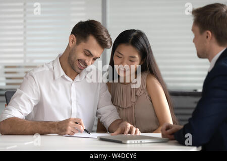 Gerne gemischte Ethnie paar Kunden unterzeichnen Hypothek Investitionskredit Vertrag Stockfoto