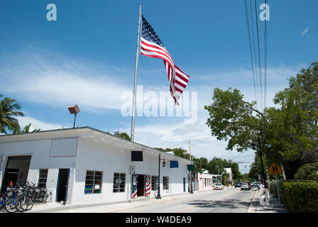 Die Ansicht von Truman Avenue mit einer großen Fahne in Key West (Florida). Stockfoto