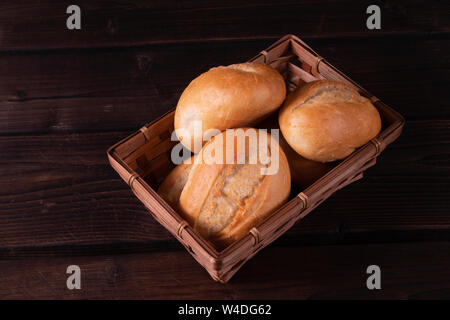 Brötchen im Brotkorb auf einer hölzernen Hintergrund, Low Key, rustikal Stockfoto
