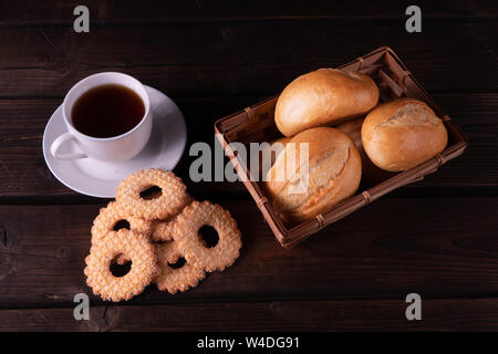 Hausgemachte Kekse und Brötchen im Brotkorb auf einer hölzernen Hintergrund, Low Key Stockfoto