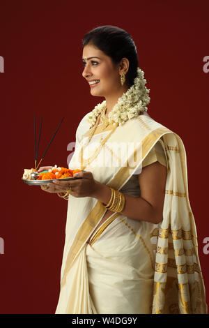 South Indian woman holding Puja thali und lächelnd Stockfoto