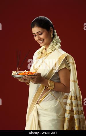South Indian woman holding Puja thali und lächelnd Stockfoto