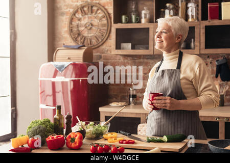 Nachdenklich zog sich Lady genießen Kaffee Pause am Küche Stockfoto