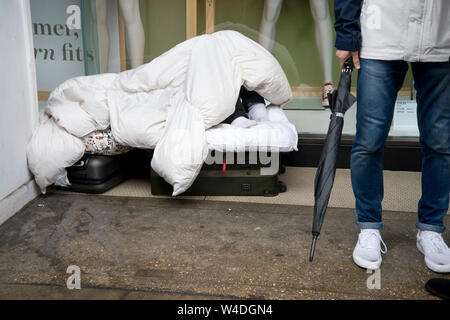 Obdachlosigkeit, Kensington. Ein obdachloser Mann schläft außerhalb der Marken und Spencers, Kensington High Street Stockfoto