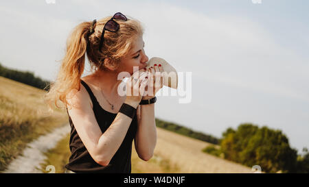 Frau mit leckeren Taco, Nahaufnahme. Die Frau befindet sich in einer malerischen Feld Stockfoto