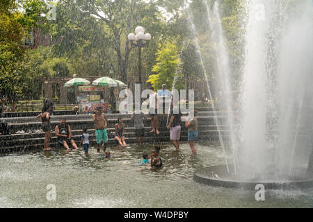 New Yorker und Besucher durch den Brunnen in den Washington Square Park in Greenwich Village in New York am Samstag tummeln, 20. Juli 2019. Eine übermäßige Wärme Warnung wird in New York ab 12.00 Uhr Freitag bis 20.00 Uhr Sonntag als der Unterdrückung in der Kombination von Wärme und Feuchtigkeit machen es sich wie 105 Grad F. (© Richard B. Levine) Stockfoto