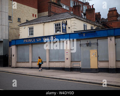 Eine Frau hinter den abgeschlossenen Prinz von Wales Pub, Norwich, Norfolk, Großbritannien Stockfoto