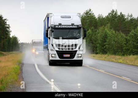 Raasepori, Finnland. Juli 5, 2019. Weißen Iveco Stralis truck zieht Trailer entlang nasse Autobahn 25 an regnerischen Tag der Sommer im Süden Finnlands, Vorderansicht. Stockfoto