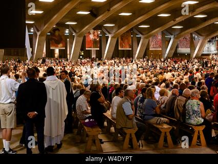 Die Teilnahme an der internationalen Messe in der unterirdischen Basilika in Lourdes, Frankreich Stockfoto