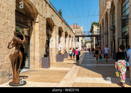 Menschen zu Fuß zu Geschäften, Boutiquen und moderne kunst Skulpturen an open-air Mamilla Mall Shopping Street in Jerusalem, Israel. Stockfoto