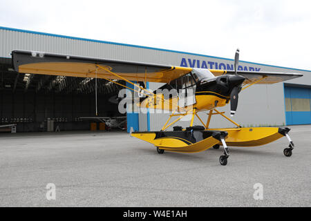 Eine gelbe Beagle Husky A-1 C durch den Hangar am Aviation Park, Hawarden Airport, Chester, UK geparkt Stockfoto