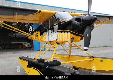 Eine gelbe Beagle Husky A-1 C durch den Hangar am Aviation Park, Hawarden Airport, Chester, UK geparkt Stockfoto