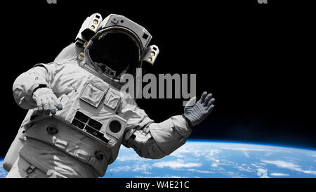 Astronauten winken während eines spacewalk in der Umlaufbahn des Planeten Erde Stockfoto